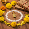Dakshinamurthy gold pendant on sandalwood with vibhuti and yellow flowers – devotional styling