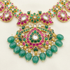 Close-up of kundan pendant with pink and green detailing and green bead drops