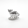 Silver cat idol on a decorative oval base against a white background