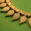 Close-up detail of intricate engraving and zircon work on mango necklace