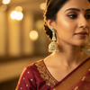 Indian bridal lifestyle - woman wearing rose gold CZ long jhumka earrings with green stones