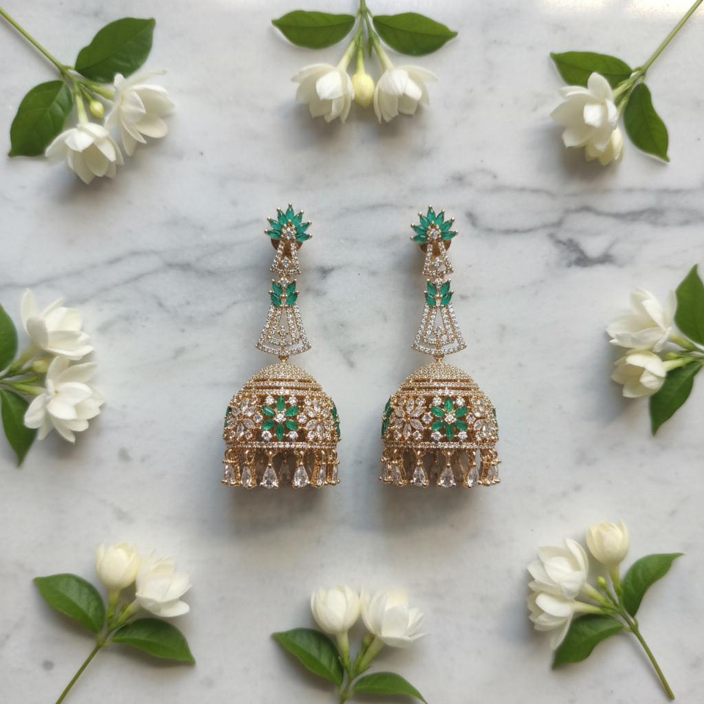 Flat lay - rose gold CZ long jhumka earrings on white marble with jasmine flowers
