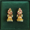 Jadau Kundan Jhumka Earrings on green velvet flat lay
