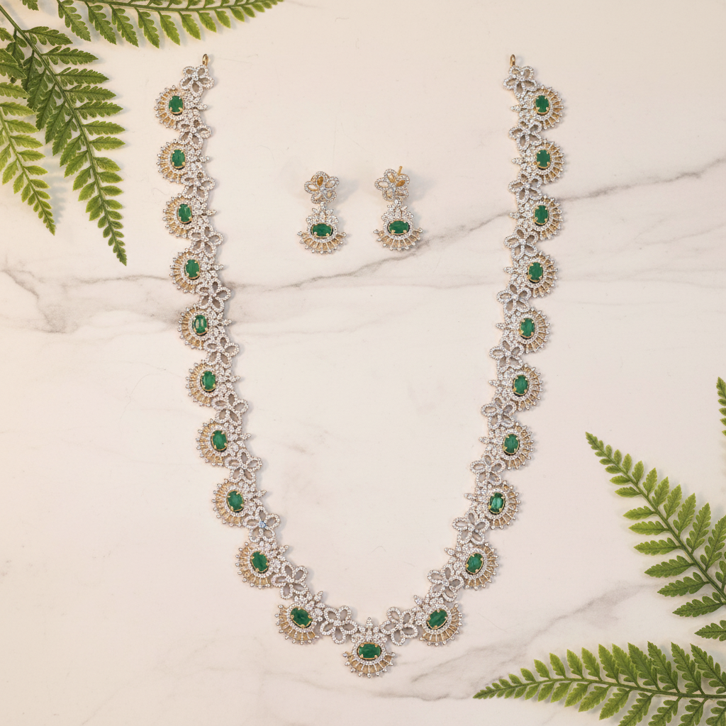 Emerald CZ necklace set lifestyle flat lay with green leaves