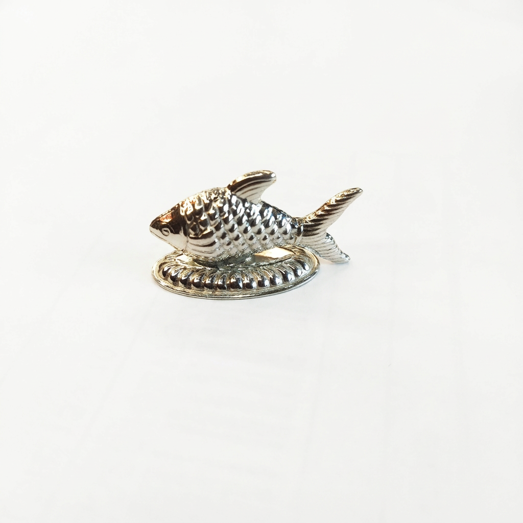 Silver fish idol with textured scales on a decorative oval base against a white background