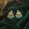 Jadau Kundan Emerald Chandbali Earrings on green velvet flat lay