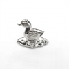 Silver duck idol with detailed wings on a decorative base against a white background