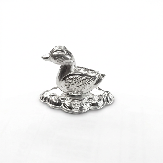 Silver duck idol with detailed wings on a decorative base against a white background