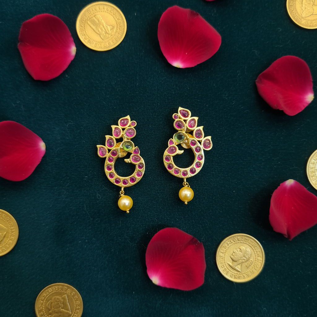 Kundan Peacock Chandbali Earrings flat lay on teal velvet with rose petals