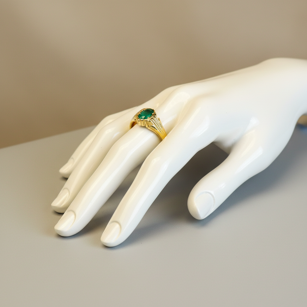 Mannequin display of gold ring with green gemstone