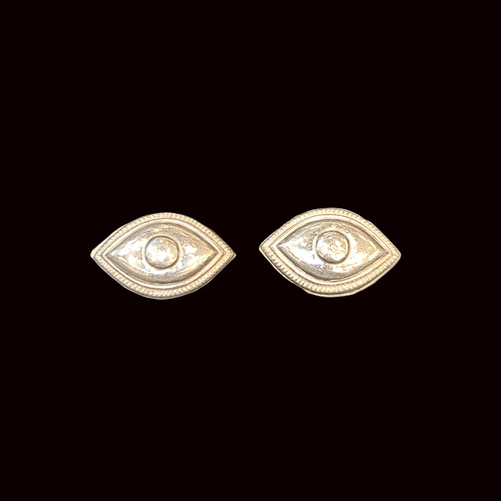 Gold eye-shaped earrings on a white background
