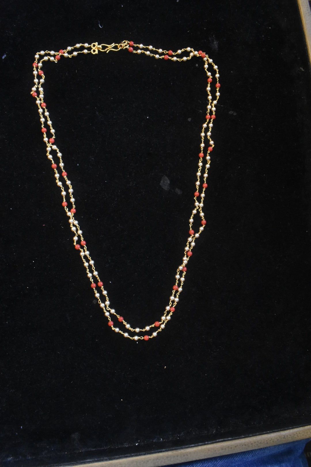 2-strand pearl and coral beaded necklace with gold links - product flat lay on black velvet