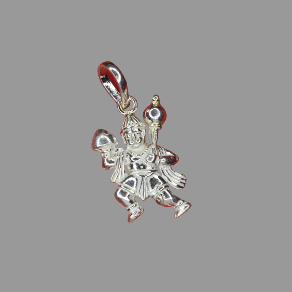 A silver-colored Hanuman pendant on a red background.