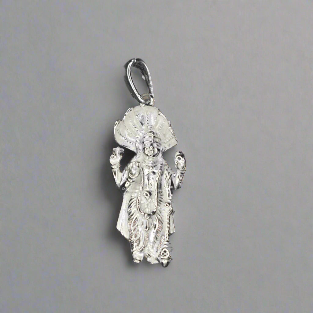 A sterling silver Lord Vishnu locket with intricate design, displayed against a rainy background.
