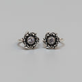A pair of silver toe rings with ruby and emerald stones