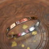 Gold bracelet with diamonds on a decorative glass surface