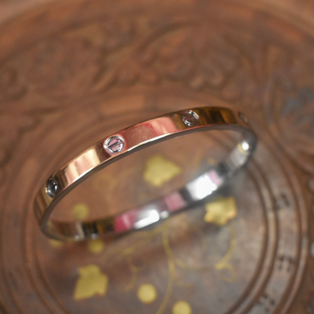 Gold bracelet with diamonds on a decorative glass surface