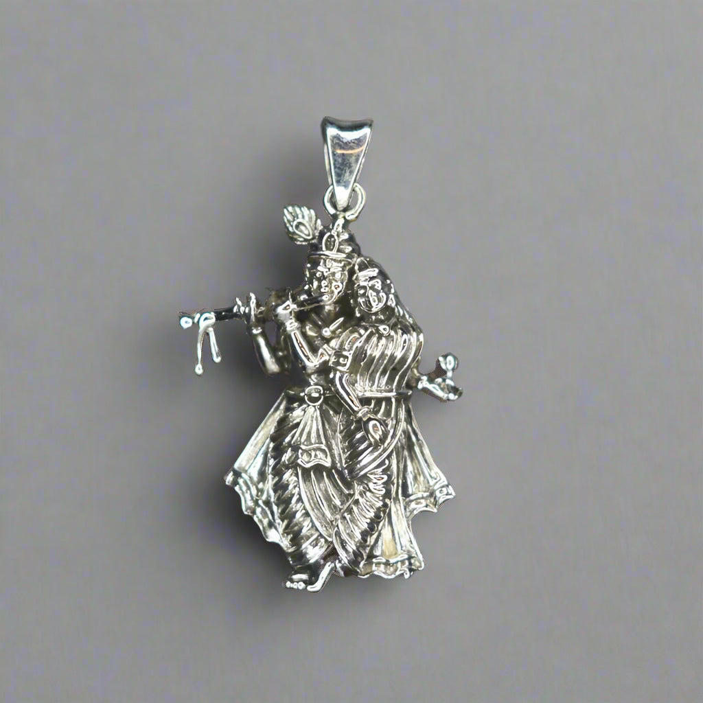 An antique pure silver pendant featuring a Radha Krishna design.