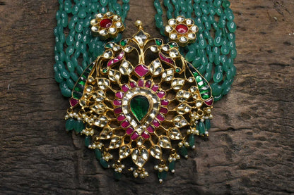 Multi strand emerald beads haram with polki pendant.