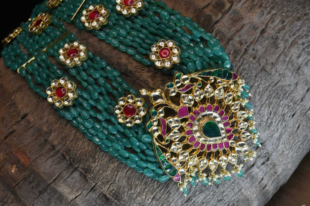 Multi strand emerald beads haram with polki pendant.