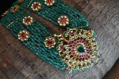 Multi strand emerald beads haram with polki pendant.